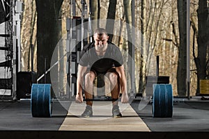 Deadlift attempt. Young man trying to lift heavy barbell