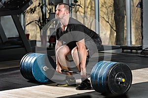 Deadlift attempt. Young man trying to lift heavy barbell