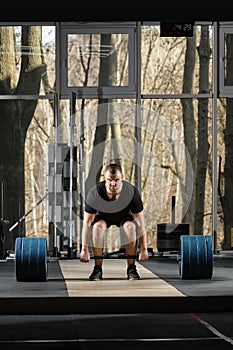 Deadlift attempt. Young man trying to lift heavy barbell