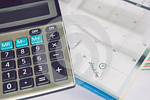 Deadline calendar reminder note and calculator on desk , business and finance concept