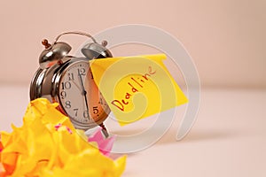 Deadline: Close-up of an alarm clock and sticky notes, emphasizing the urgency