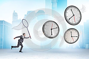 Deadline concept with businessman catching clocks