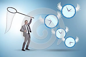 Deadline concept with businessman catching clocks