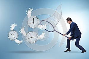 Deadline concept with businessman catching clocks