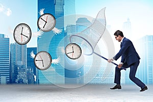 Deadline concept with businessman catching clocks