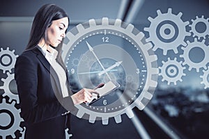 Deadline concept with businesswoman working with digital tablet on virtual background with clock and gears