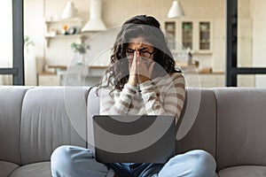Deadline stress. Desperate young woman crying near laptop, having trouble performing work task, making mistake at home