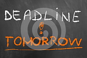 Deadline tomorrow chalk text on blackboard or chalkboard