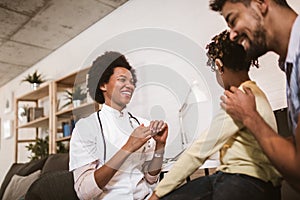 Deaf african american girl with ear implant at doctor`s office