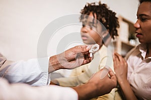 Deaf african american girl with ear implant at doctor`s office