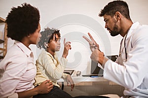 Deaf african american girl with ear implant at doctor`s office