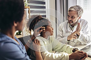 Deaf african american girl with ear implant at doctor`s office