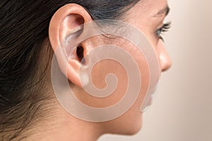 Deaf caused by earphones. close up view of woman`s ear