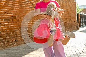 Deaf child with cochlear implant for hearing audio and aid for impairment having fun and laughs with mother outdoor in