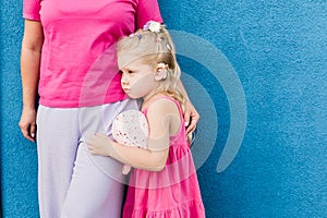 Deaf child with cochlear implant for hearing audio and aid for impairment having fun and laughs with mother outdoor in