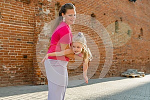 Deaf child with cochlear implant for hearing audio and aid for impairment having fun and laughs with mother outdoor in