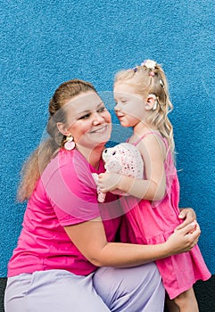 Deaf child with cochlear implant for hearing audio and aid for impairment having fun and laughs with mother outdoor in