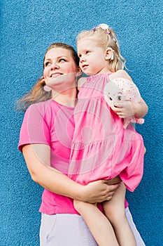 Deaf child with cochlear implant for hearing audio and aid for impairment having fun and laughs with mother outdoor in