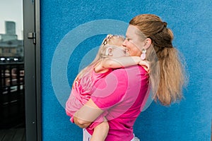 Deaf child with cochlear implant for hearing audio and aid for impairment having fun and laughs with mother outdoor in