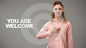 Deaf female saying you are welcome in asl, text on background, interpreter