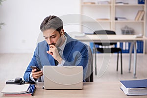 Deaf male employee using hearing aid at workplace