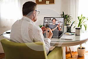 Deaf man talking using sign language on the laptop