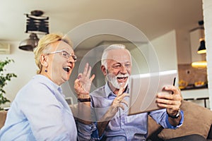 Deaf senior couple talking using sign language on the digital tablet`s cam