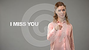 Deaf woman saying miss you in sign language, text on background, communication