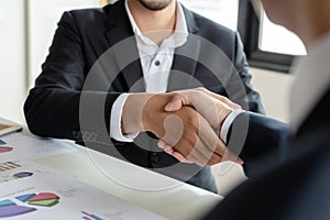 Deal. business people handshake after business signing contract document on desk in meeting room