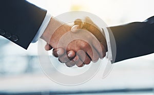 The deal makers. Closeup shot of two businessmen shaking hands in an office.