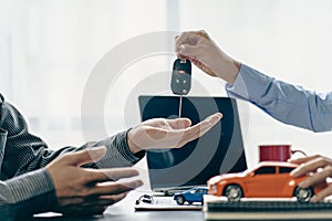 The dealer or dealership gives the car keys to the new owner. Customer signs insurance document or rental car