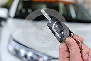 Dealer holding keys from new car close up