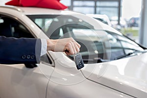 Dealer holding keys to a new car. Modern and prestigious vehicles.