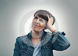 Dear brain, why have you failed me so. Studio shot of a senior woman scratching her head in confusion against a grey