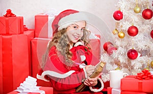Dear santa. Believe in miracle. Girl little cute child hold pen and paper near christmas tree. Wish list. Letter for
