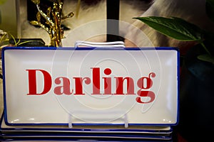 Dearling on a rectangle dish displayed in a store with blurred gold and fur items and leaf in background