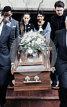 Death, funeral and people with coffin to cemetery, graveyard and morgue for burying, cremation or ritual. RIP, mourning