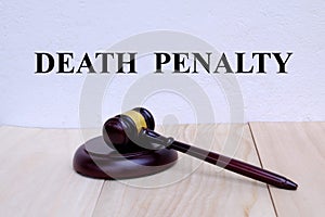 Death Penalty written on the wall with gavel on wooden background. Law concept photo