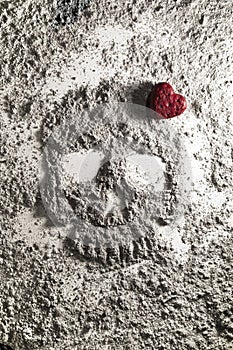 Death skull with red love heart made of ash