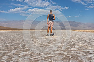 Death Valley - Man looking at scenic view of Badwater Basin salt flats in Death Valley National Park, California, USA