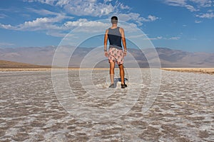 Death Valley - Man looking at scenic view of Badwater Basin salt flats in Death Valley National Park, California, USA