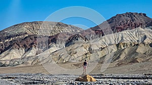 Death Valley - Man with scenic view of colourful multi hued Amargosa Chaos rock formations in Death Valley National Park, USA