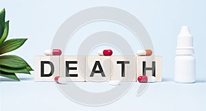DEATH word made with building blocks. A row of wooden cubes with a word written in black font is located on white background