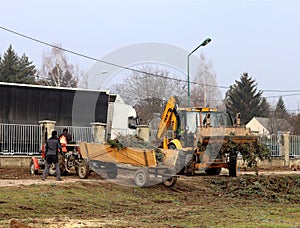 Debowiec/Poland - March 27, 2018: Spring cleaning of green territory in the city. Tractor and excavator for upgrading the green pl