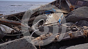 Debris of a fishing ship on a rocky seaside. Shipwreck concept. Storm on a sea. Tsunami concept