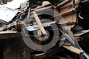 Debris and wooden remains and garbage pile on a stack on demolition site of a building