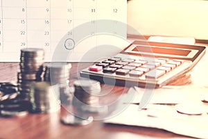 Debt collection and tax season concept with deadline calendar remind note,coins,banks,calculator on table photo