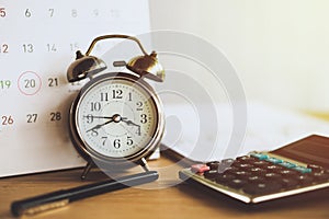 Debt collection and tax season concept with due date on calendar with alarm clock and calculator