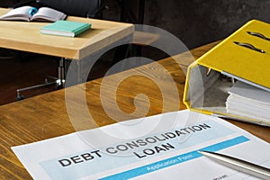 Debt consolidation loan application near yellow folder.
