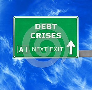 DEBT CRISES road sign against clear blue sky